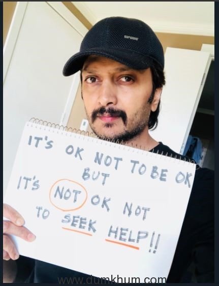 Riteish Deshmukh holding up the Its ok not to be ok placard
